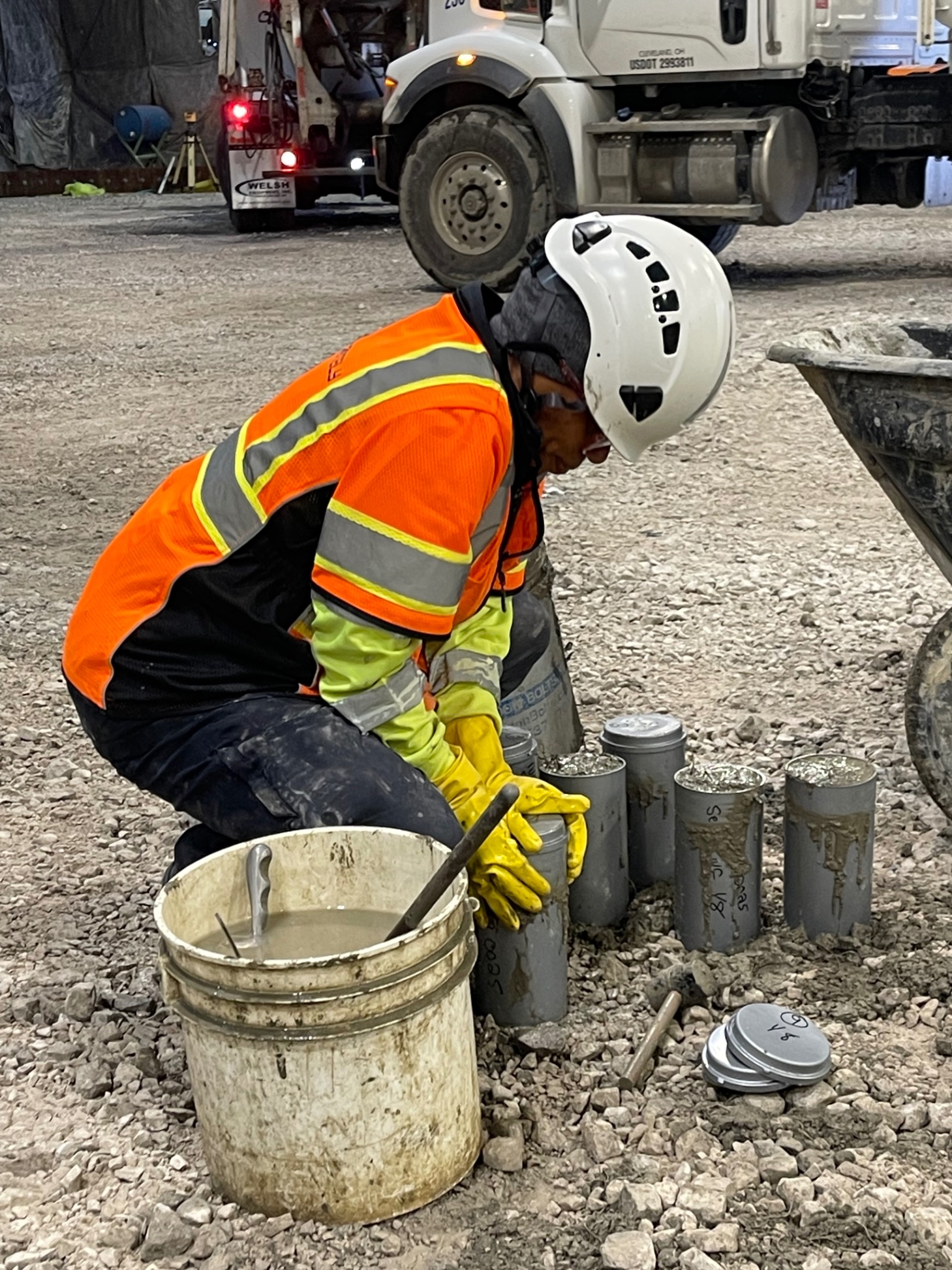 Technician filling concrete test cylinders